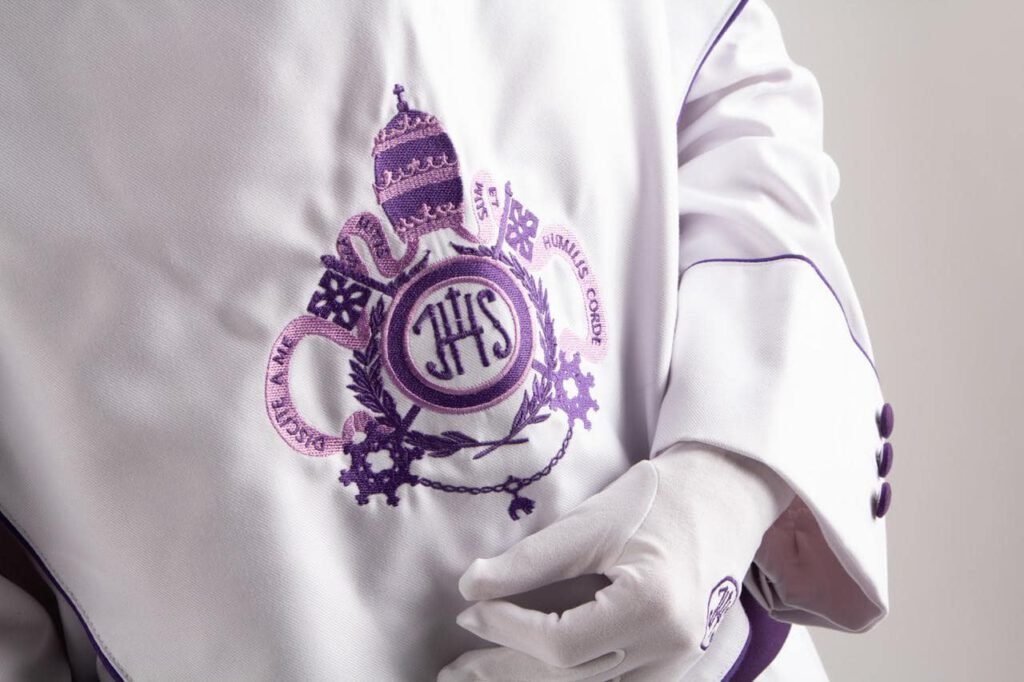 Detalle del escudo bordado en la túnica de un capuchón